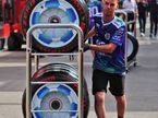 Racing Bulls Formula One Team mechanic pushes Pirelli tyres through the paddock
